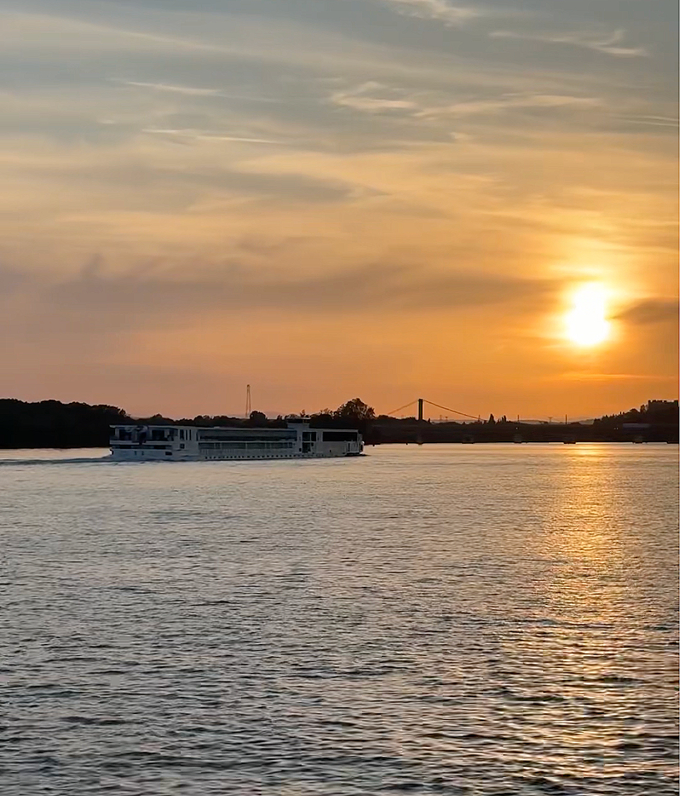 A river cruise ship sailing the Rhône at sunset.
